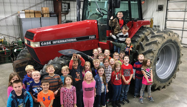 Hardin Northern first-graders pose around tractor after FFA lesson